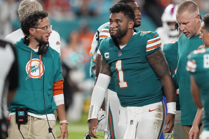 Miami Dolphins head coach Mike McDaniel talks to quarterback Tua Tagovailoa (1) as he leaves the game.