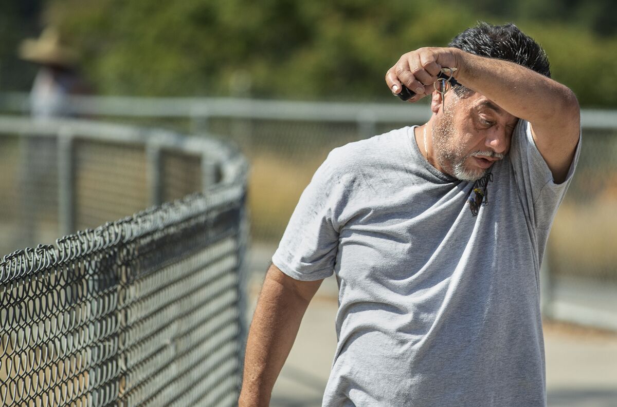Miguel Garcia of Tujunga wipes the sweat off of his face Friday after jogging at Hansen Dam Recreation Area in Pacoima.