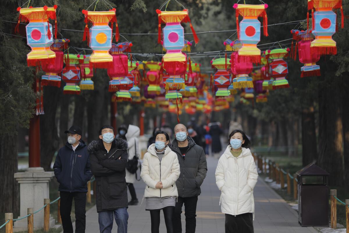 People wear masks in Jingshan Park in Beijing. The capital canceled many celebrations and closed many attractions, including the Forbidden City, because of the coronavirus outbreak.