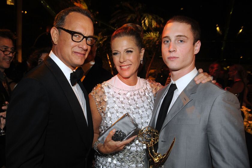 Tom Hanks, Rita Wilson and Chet Hanks posing for a photo in a dark room