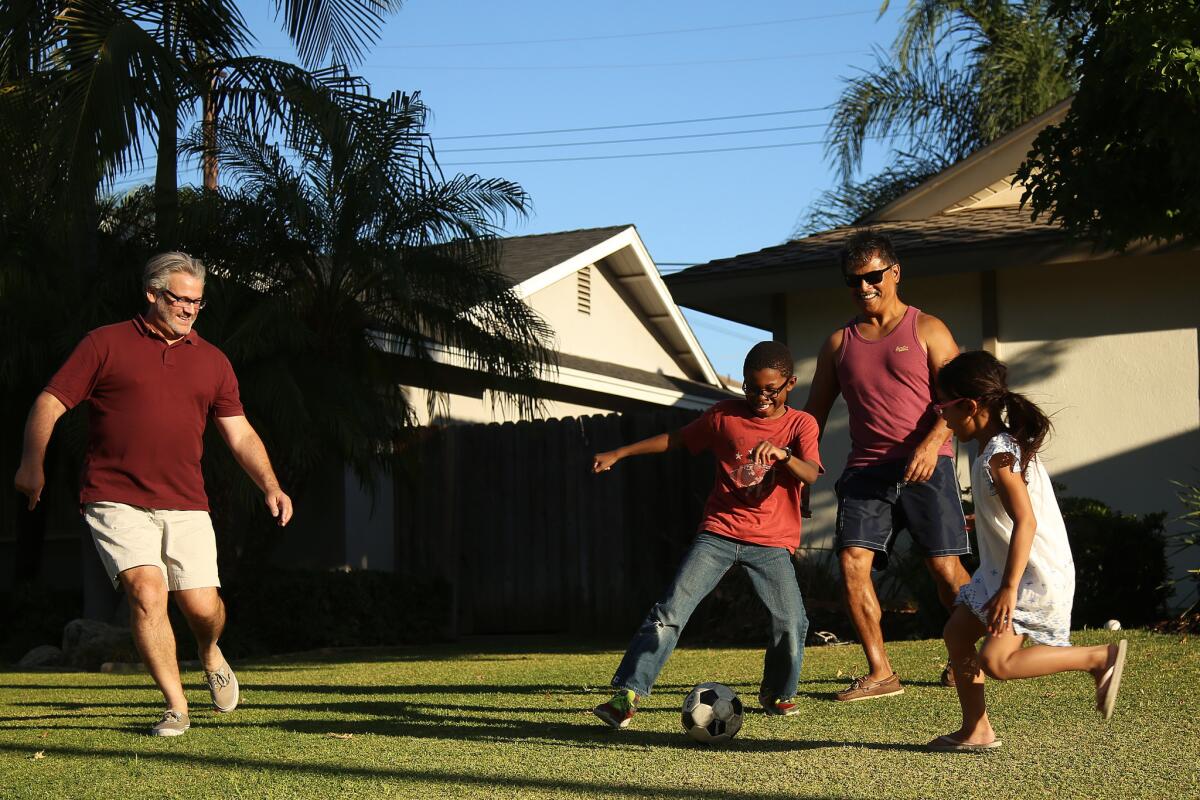 Matthew Mansell, left, and John Espejo play soccer with their children Wyatt, 8, and Elyse, 7, right. The family recently returned to California after living in Tennessee, where they say they were not as accepted by the community.