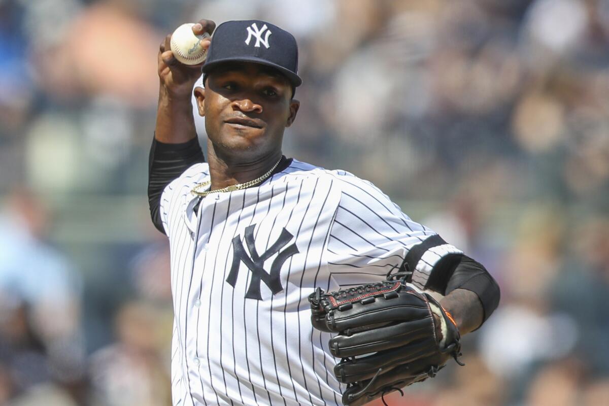 FILE - In this Aug. 31, 2019, file photo, New York Yankees pitcher Domingo German throws to first in a pickoff-attempt during the fifth inning of a baseball game against the Oakland Athletics in New York. German has started the process of talking to teammates about his domestic violence suspension that has kept him off the mound since September 2019. (AP Photo/Mary Altaffer, File)