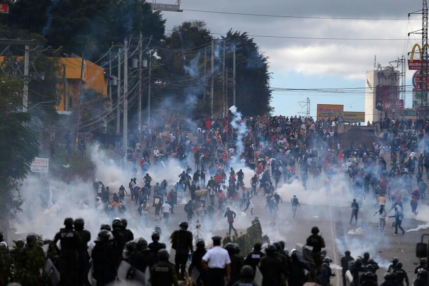 Soldiers and police launch tear gas at demonstrators marching to the national stadium to protest the presidential inauguration of Juan Orlando Hernandez, in Tegucigalpa, Honduras, Saturday, Jan. 27, 2018. Hernandez was sworn in for a second term amid protests against the November election that was marred by irregularities and allegations of fraud. (AP Photo/Eduardo Verdugo)