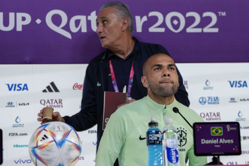 Brazil's Dani Alves, front, head coach Tite attend a press conference on the eve of the group G of World Cup soccer match between Brazil and Cameroon in Doha, Qatar, Thursday, Dec. 1, 2022. (AP Photo/Andre Penner)