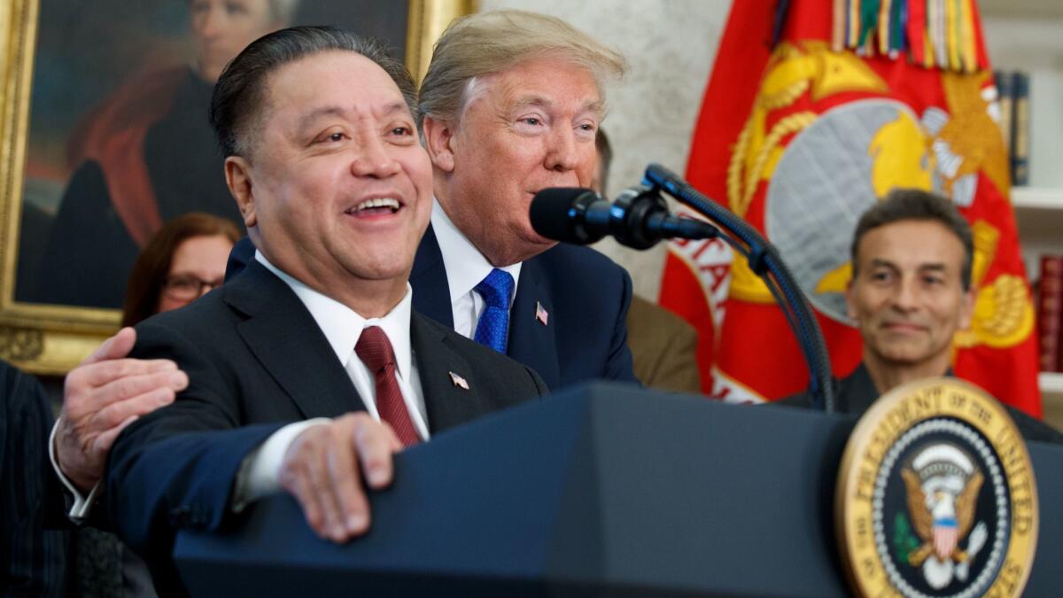 President Trump hugs Broadcom CEO Hock Tan during an event to announce the company is moving its global headquarters to the United States, in the Oval Office of the White House on Nov. 2.