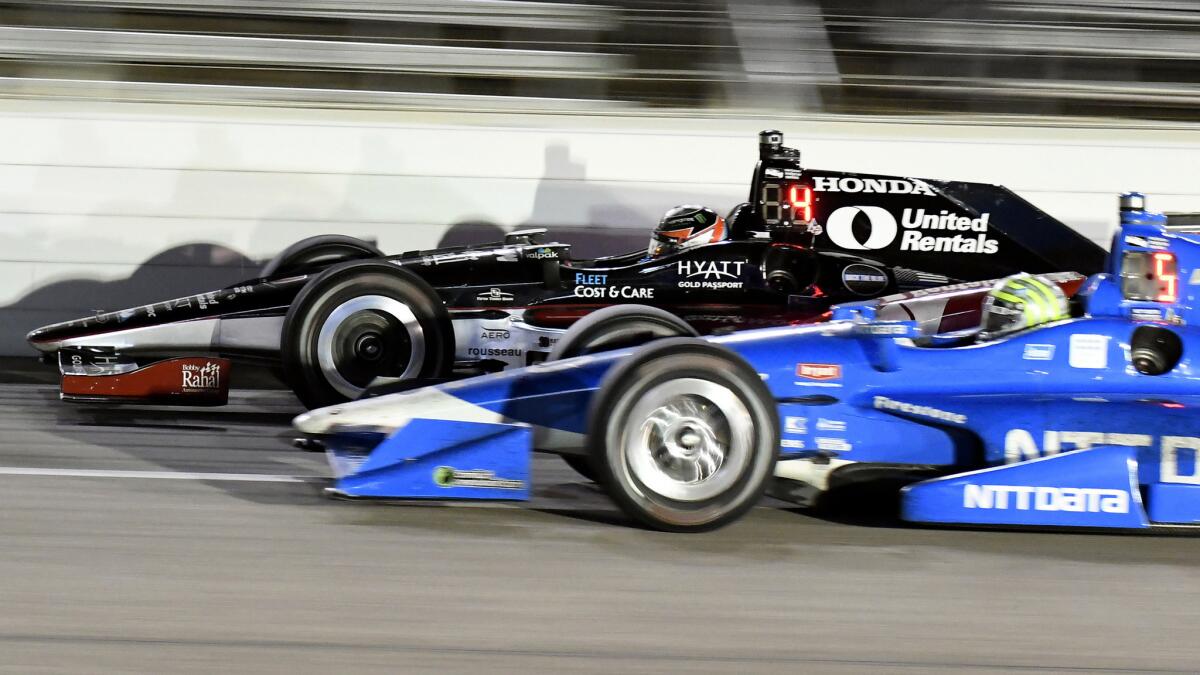 IndyCar drivers Graham Rahal (black car) and Tony Kanaan race side by side during the IndyCar race Saturday night in Texas.