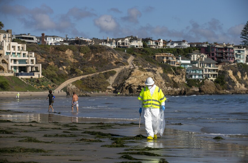 A worker on the beach at Corona del Mar State Beach on Tuesday, Oct. 5.