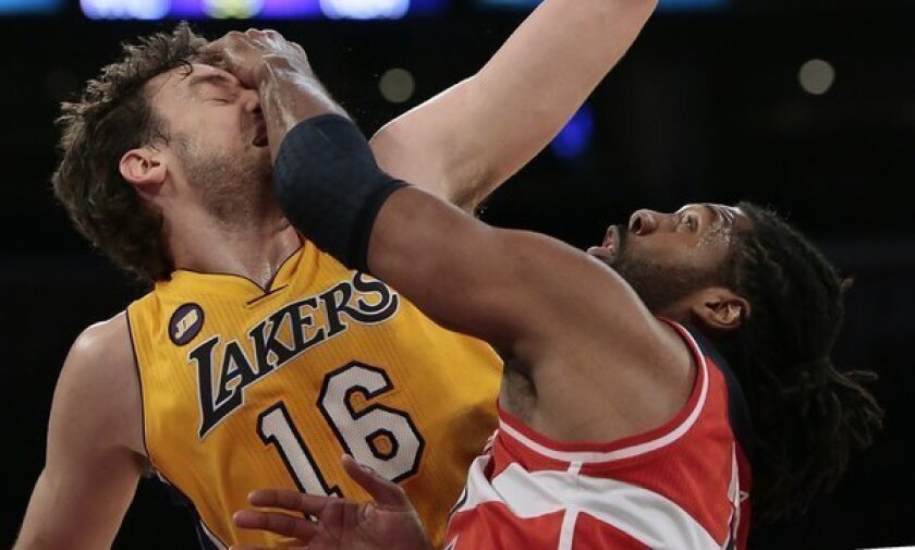 Wizards big man Nene smacks Lakers forward Pau Gasol across the face during a jump ball during the first half.