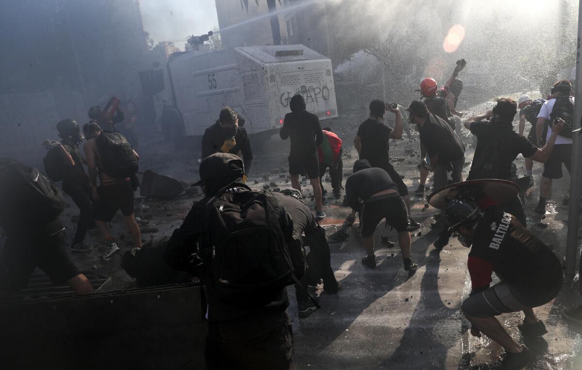 Protesters attack a police armored vehicle in Santiago, Chile.