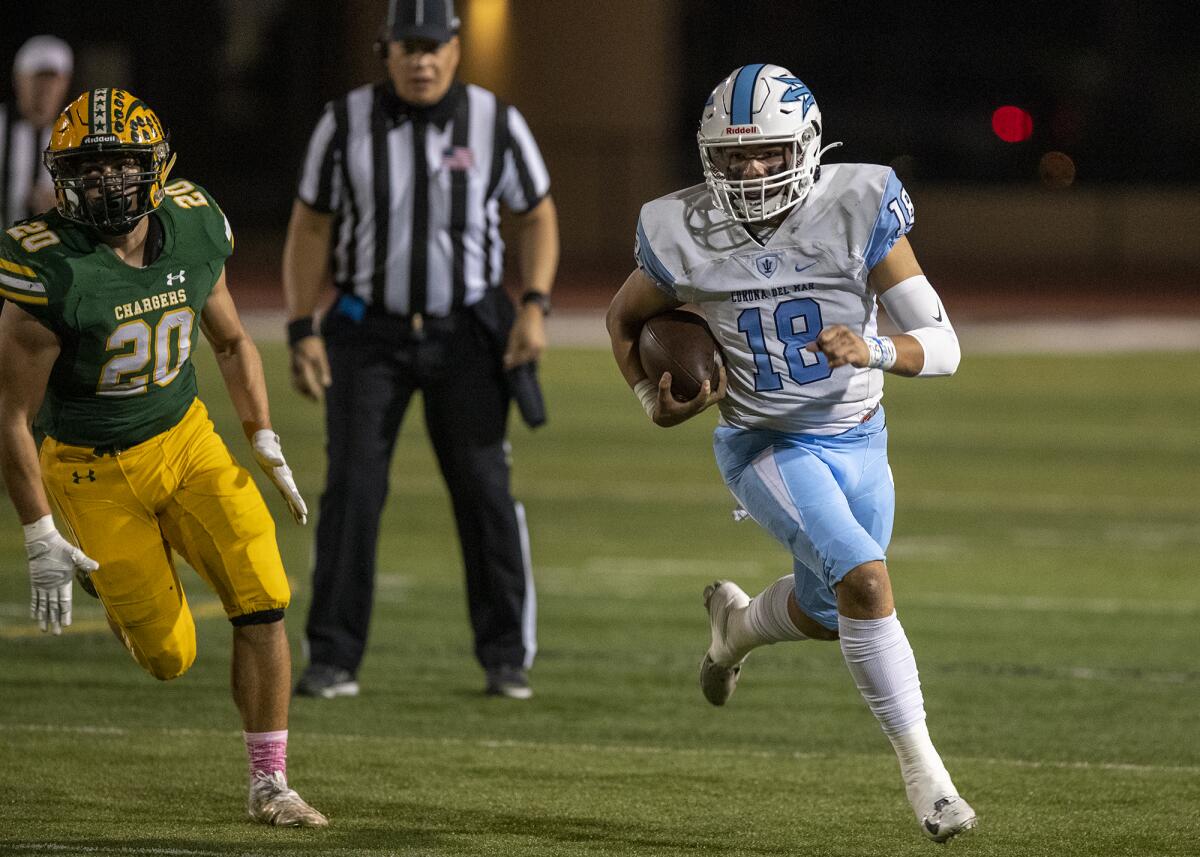 Corona del Mar's David Rasor runs up field under pressure from Edison's Peyton Gregory during a Sunset League football game.