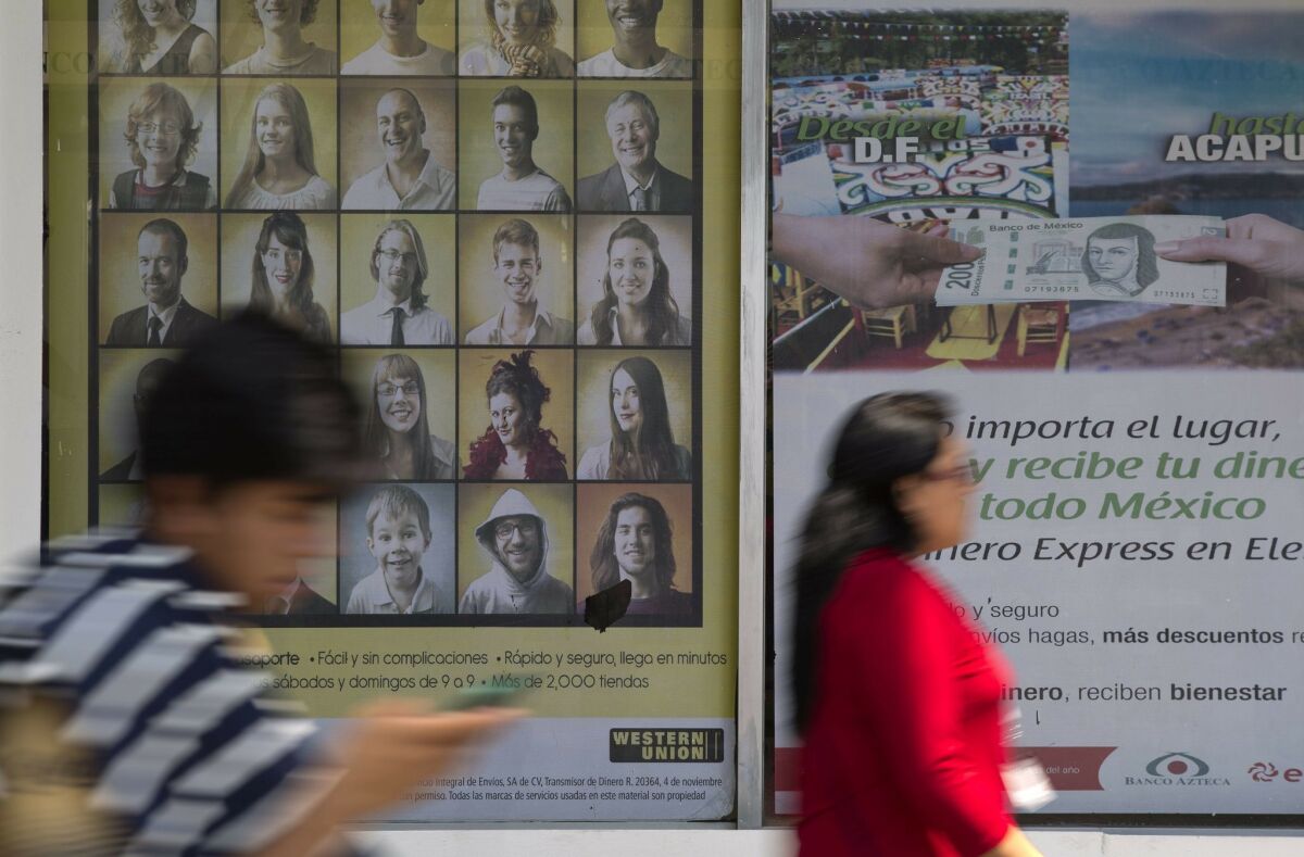 Signs advertising money transfer services outside a business in Mexico City