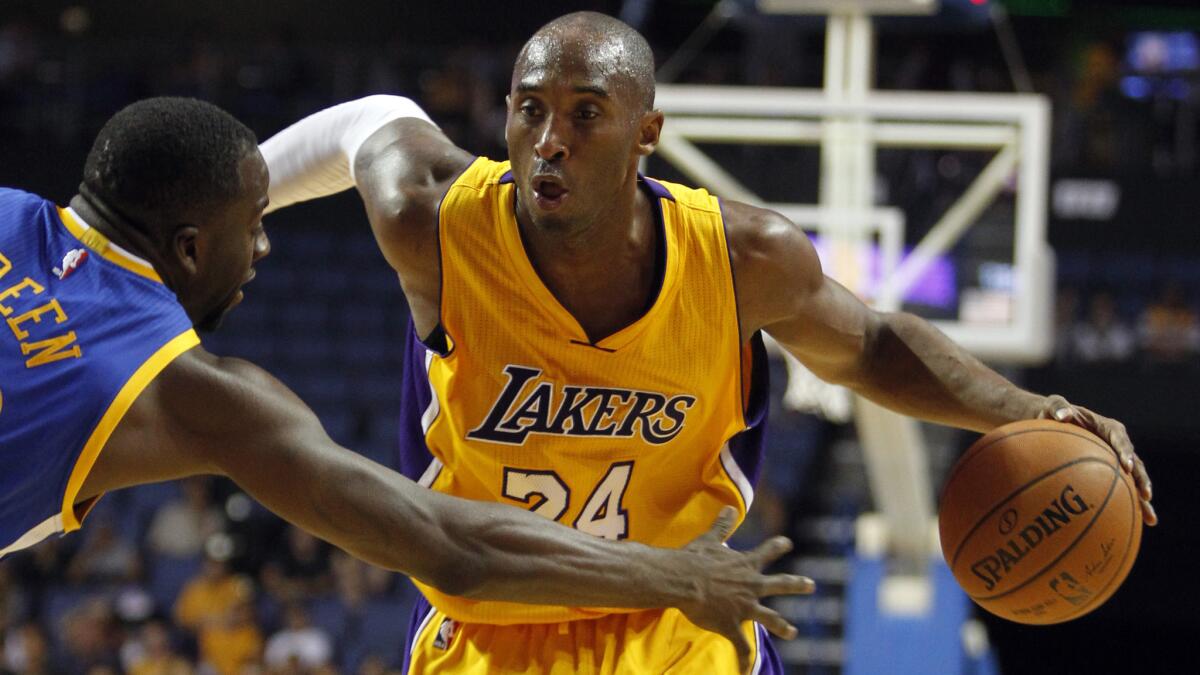 Lakers star Kobe Bryant tries to drive past Golden State Warriors forward Draymond Green during the first half of Sunday's preseason loss.