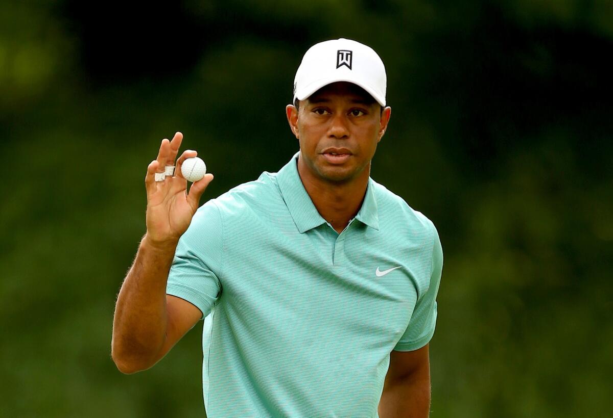 Tiger Woods waves to the gallery after making his putt on the 16th hole during the first round of the Greenbrier Classic on Thursday at Old White TPC in White Sulphur Springs, W.Va.