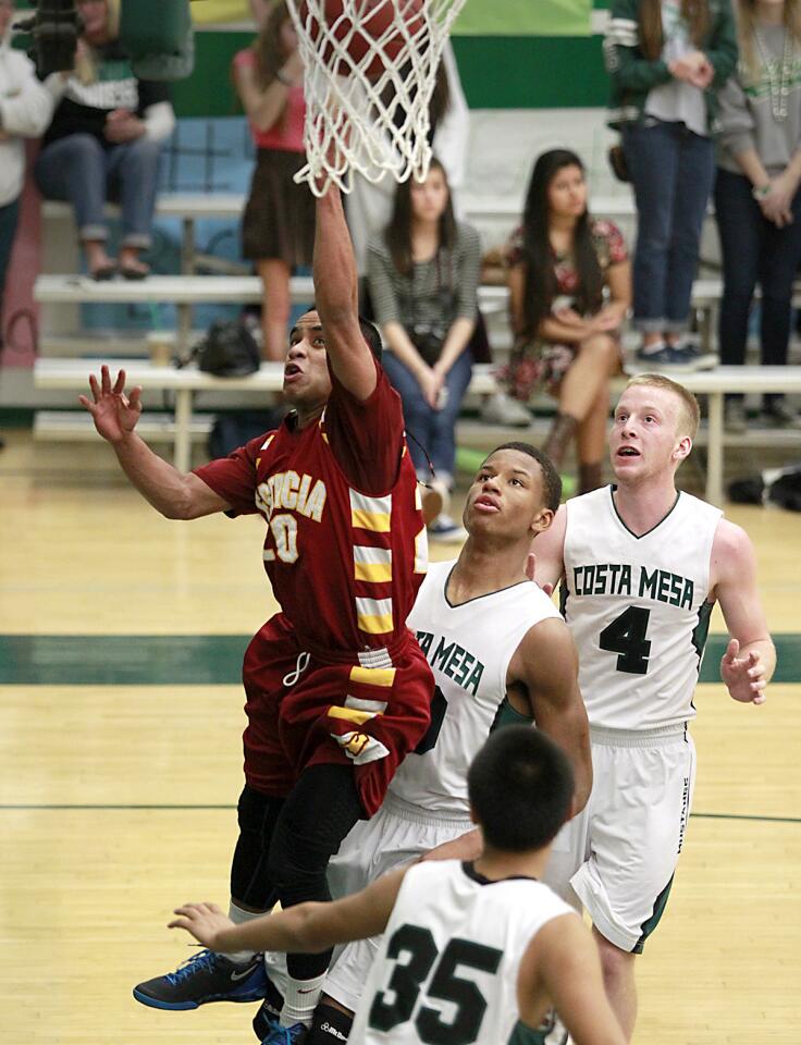 Estancia's Martin Harry drives the basket for a lay-up bringing Estancia closer during third period Orange Coast League game action on Wednesday at Costa Mesa.