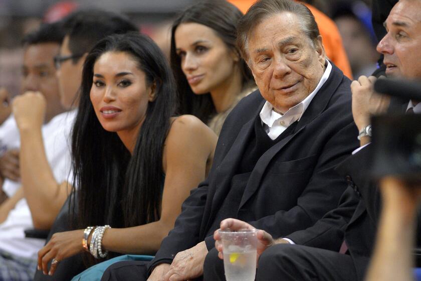 Then-Clippers owner Donald Sterling and V. Stiviano attend a game against the Sacramento Kings in 2013.