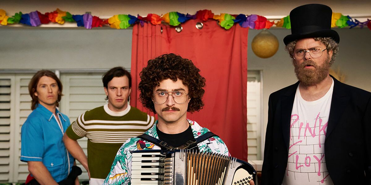 Four men, including one with an accordion and one with a top hat, in the movie "Weird: The Al Yankovic Story."