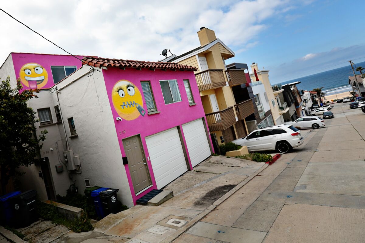 The hot-pink house adorned with two giant emojis that roiled a Manhattan Beach neighborhood has sold  for $1.55 million.