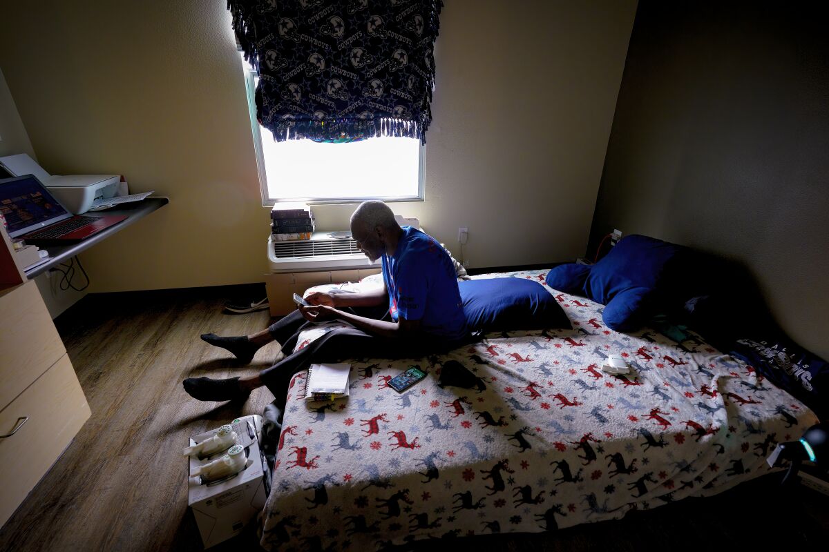 Frazier Johnson, 52 sat on the mattress in his studio apartment as he caught up with his emails.