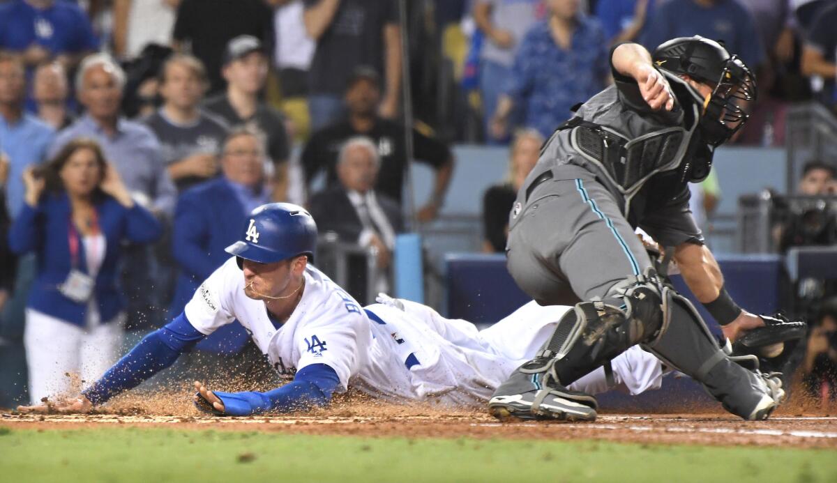 Dodgers first baseman Cody Bellinger beats the throw to Diamondbacks catcher Jeff Mathis on a double by Yasiel Puig in the first inning of Game 1 of the NLDS at Dodger Stadium.
