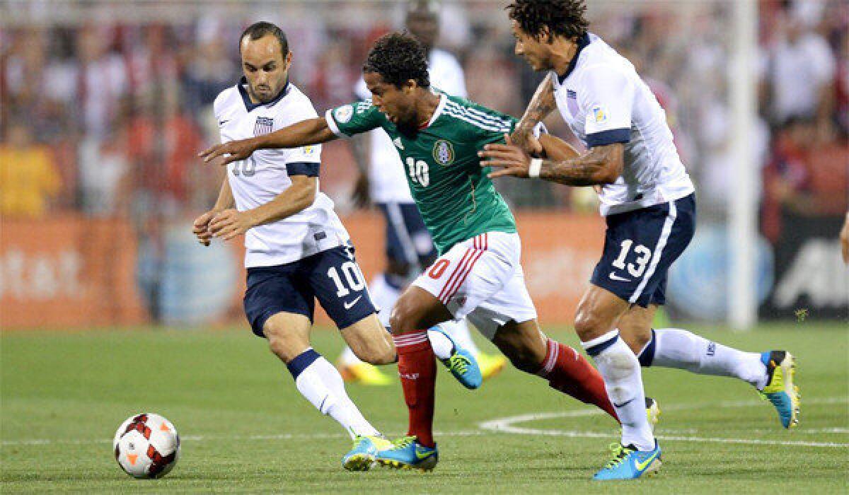 Landon Donovan, left, and Jermaine Jones, right, of the U.S. men's national team defend against Mexico's Giovani dos Santos on Sept. 10.