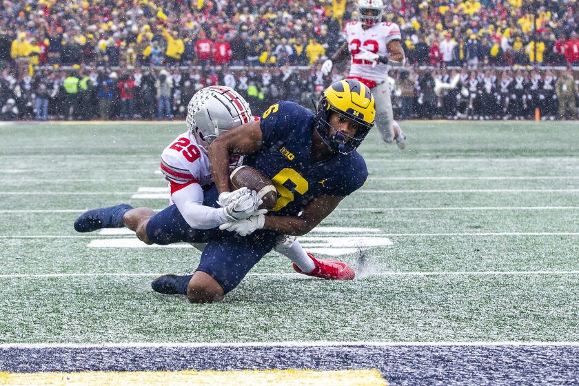 Ohio State cornerback Denzel Burke (29) tackles Michigan wide receiver Cornelius Johnson (6) short of the goal line in the second quarter of an NCAA college football game in Ann Arbor, Mich., Saturday, Nov. 27, 2021. (AP Photo/Tony Ding)