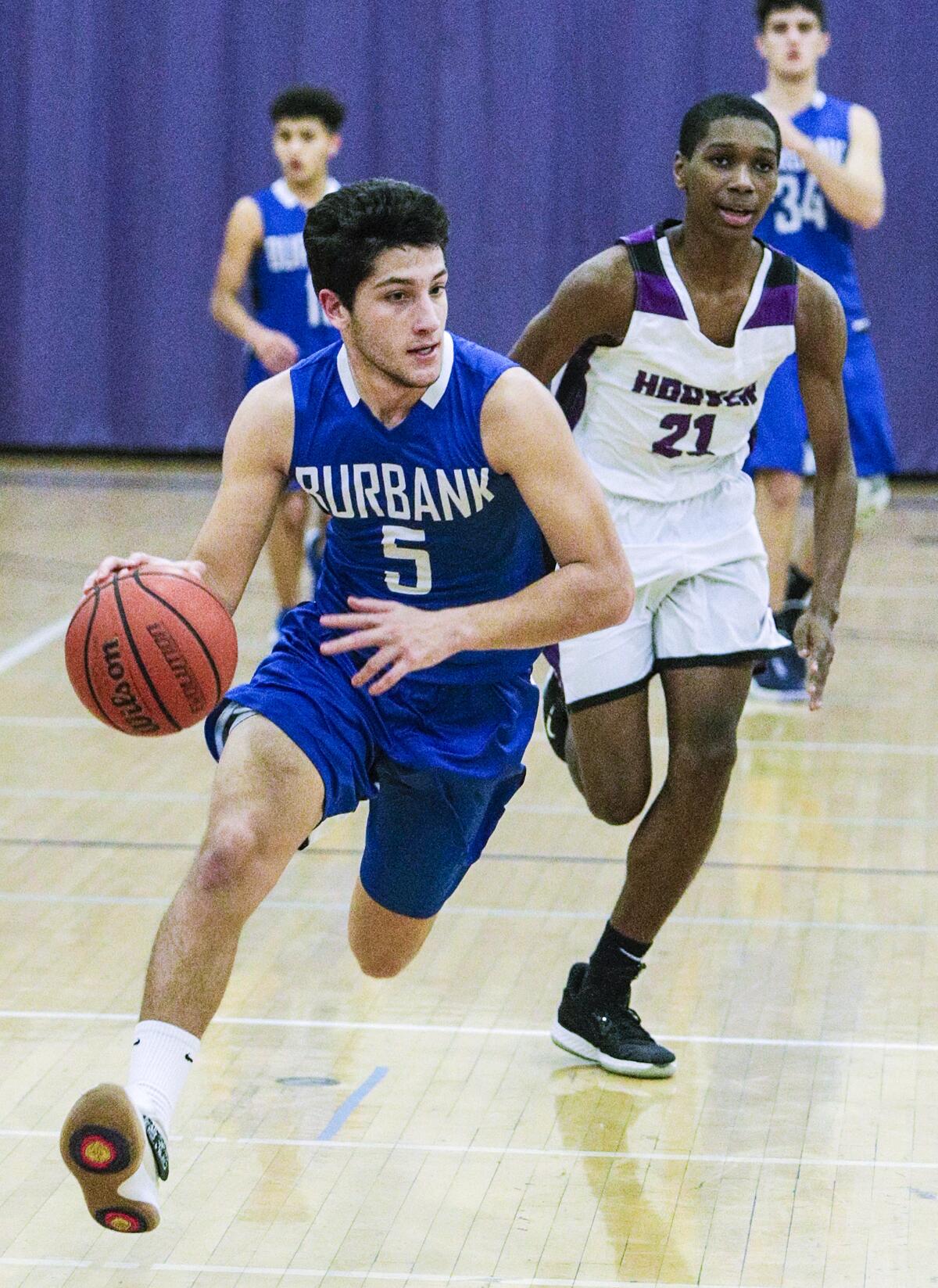 Burbank's Ben Burnham brings the ball up court with Hoover's Jeremiah Townsend trailing in a Pacific League boys' basketball game at Hoover High School on Friday, January 3, 2020.