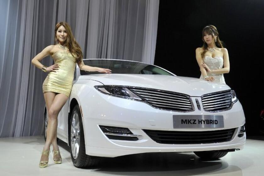 South Korean models pose with the all-new Lincoln MKZ Hybrid at the Seoul Motor Show last month. KBB says, "Lincoln's gas/electric mid-size sedan is as contemporary a vehicle we've seen from the automaker in a long time." City/highway/combined mpg: 45/45/45. MSRP: $36,800.