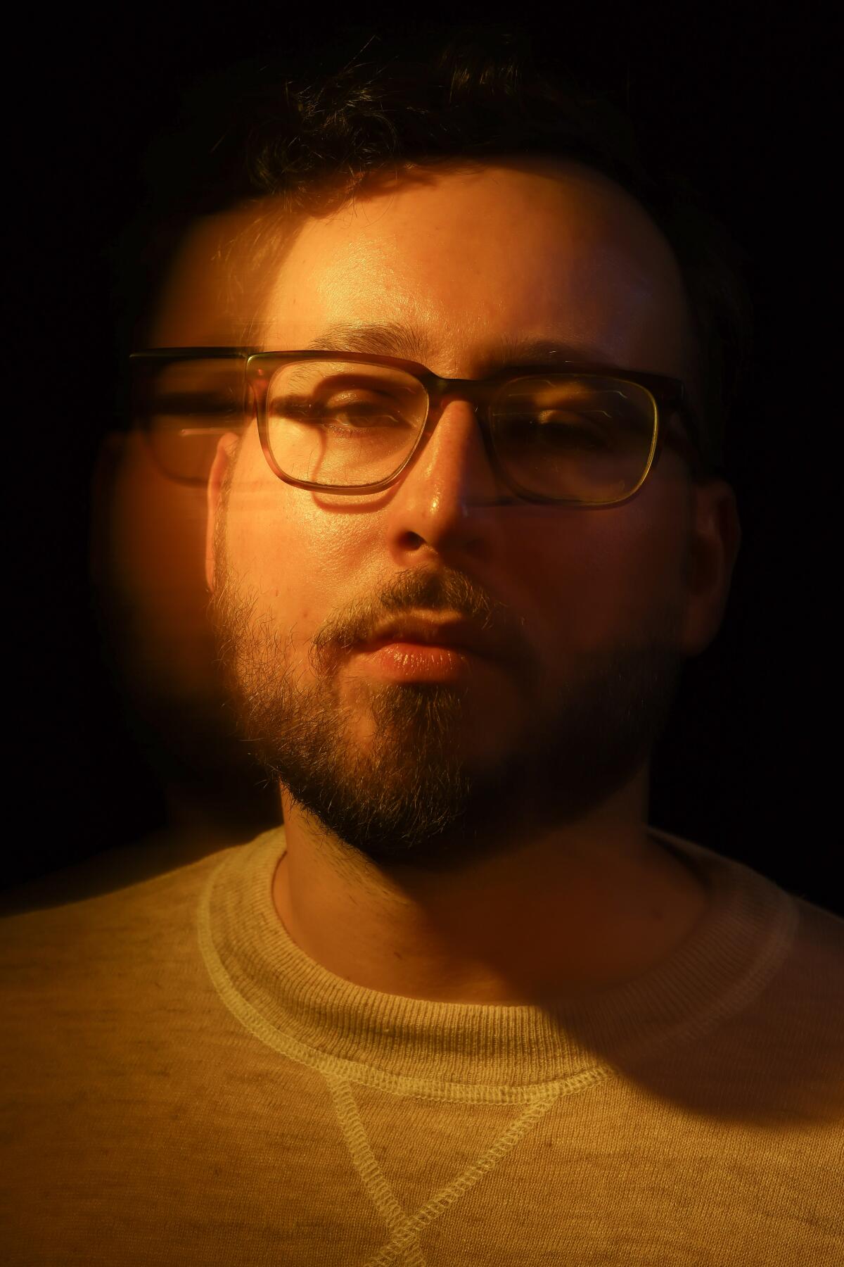 A headshot of a man wearing glasses.
