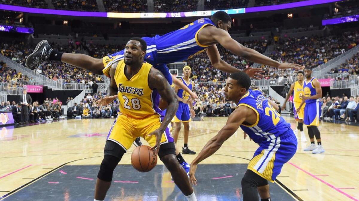 Lakers center Tarik Black is fouled by Warriors forward Kevon Looney during a game in Las Vegas on Saturday.