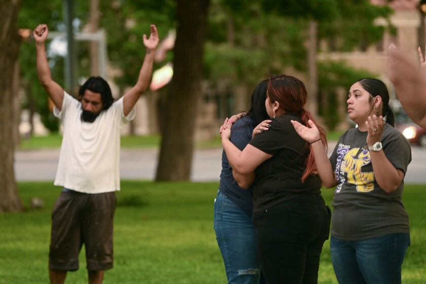 People pray and comfort one another during a vigil for the victims that died in a mass shooting at Robb Elementary School, in Uvalde, Texas, on Tuesday, May 24, 2022. (Billy Calzada/The San Antonio Express-News via AP)