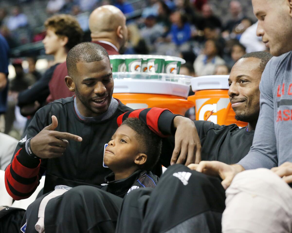 Clippers point guard Chris Paul talks with son Chris Jr. during the fourth quarter of a blowout victory over the Mavericks.