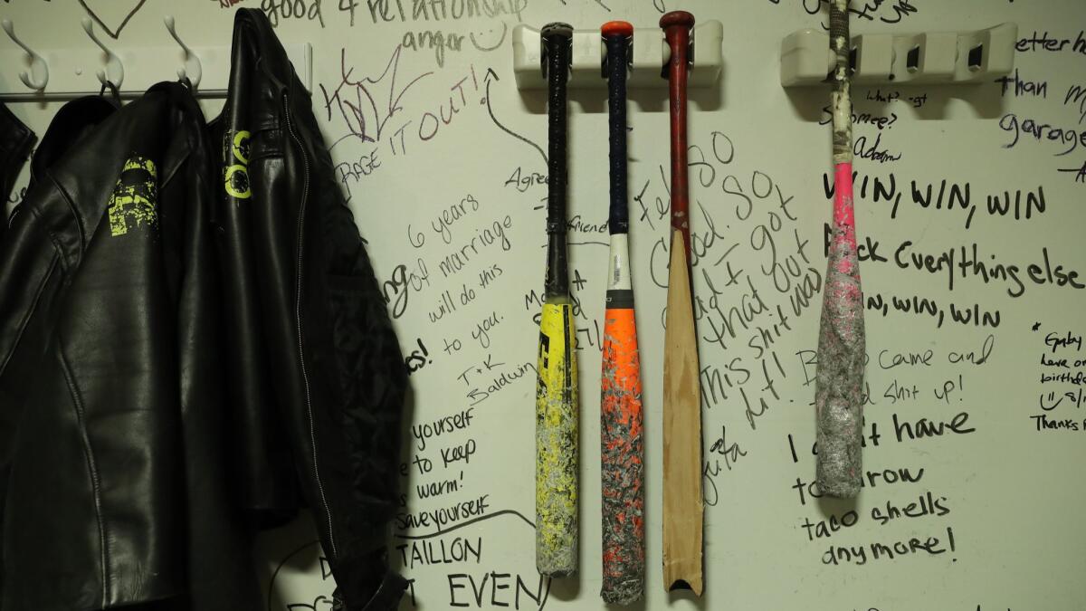 Protective jackets and bats are hung on a wall with messages from users of a rage room on Aug. 24, 2018, at the Escapades Chicago Escape and Rage Room, in Chicago's River North neighborhood.