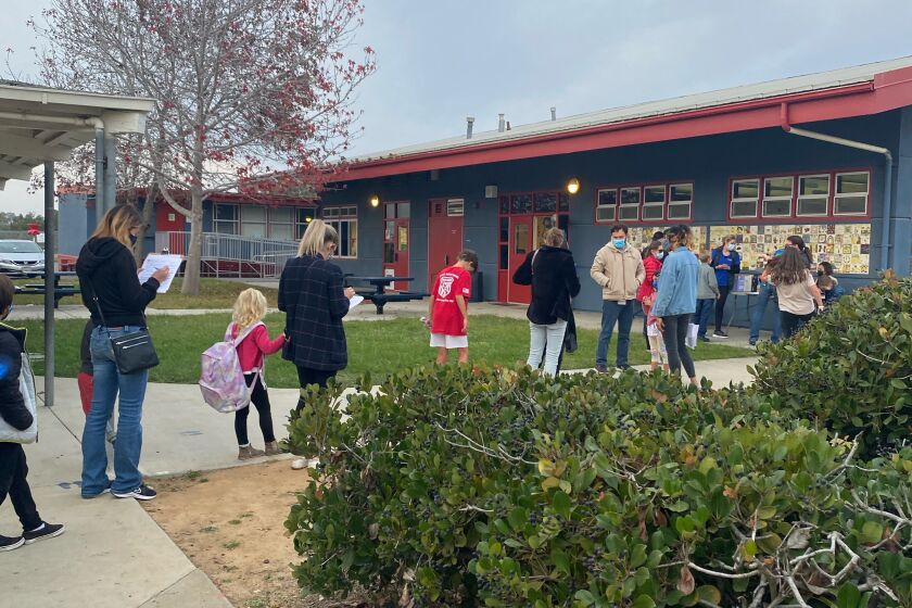 Parents and students wait at Torrey Pines Elementary School's COVID-19 and flu vaccine clinic Dec. 6
