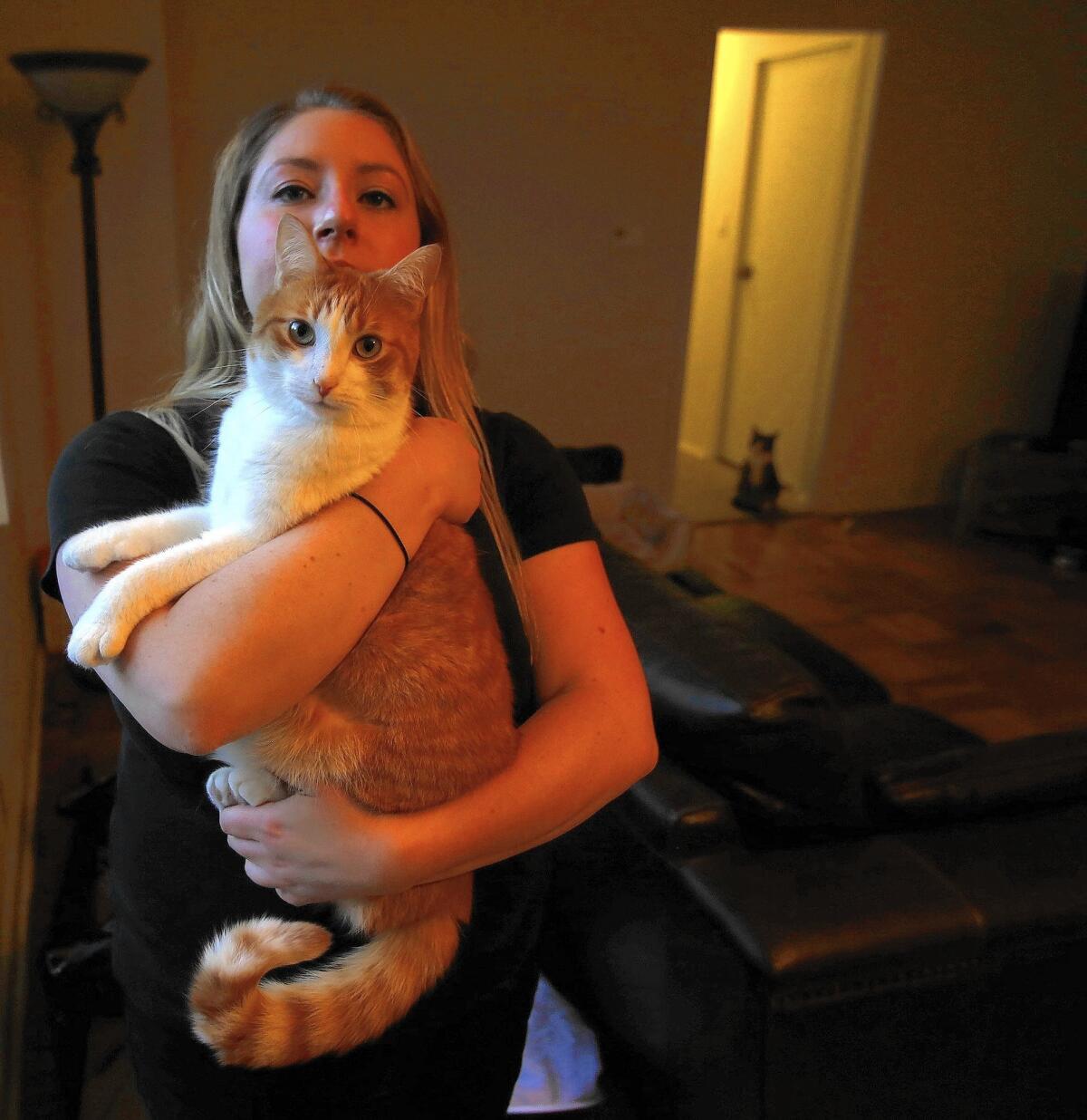 Alissa Kirby holds her cat, Butters. Kirby says she believes a police dog attacked her pet, costing her nearly $1,000 in veterinarian bills.