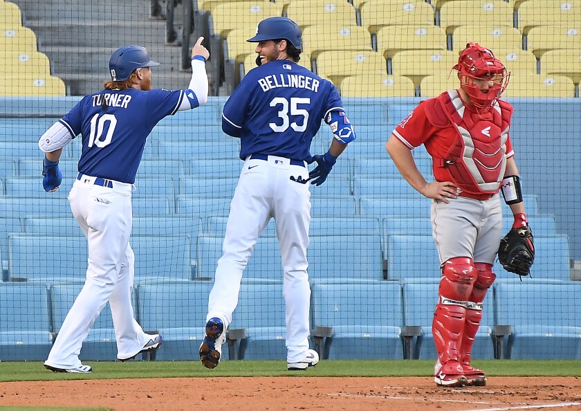 The Dodgers' Cody Bellinger celebrates his two-run home run with Justin Turner as Angels catcher Max Stassi looks on.