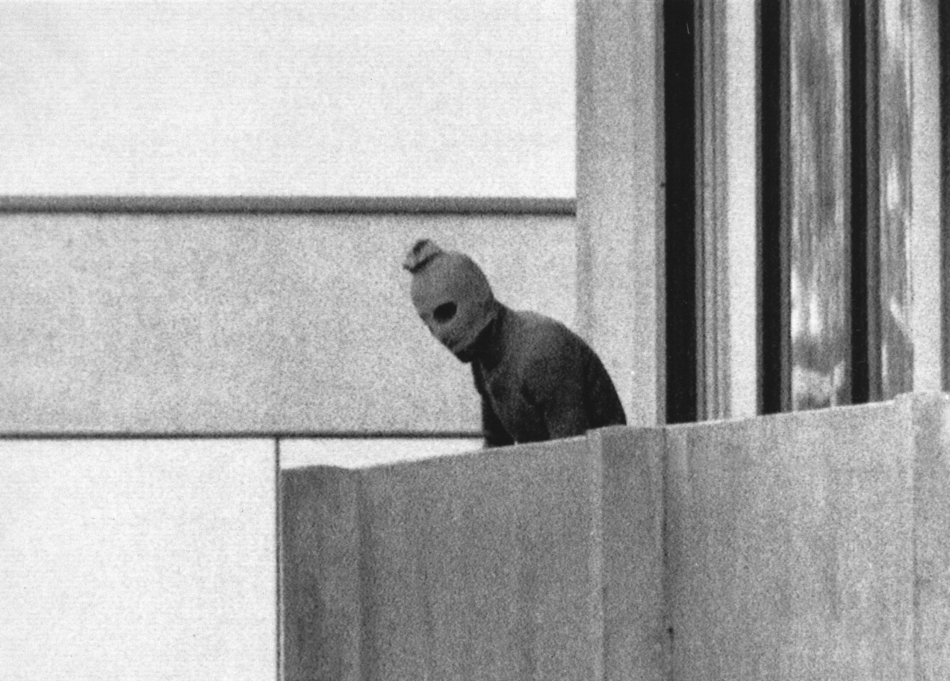 FILE - In this Sept. 5, 1972 b/w file photo, a member of the Arab Commando group which seized members of the Israeli Olympic Team at their quarters at the Munich Olympic Village appears with a hood over his face on the balcony of the village building where the commandos held members of the Israeli team hostage. The presidents of Germany and Israel will jointly commemorate the 45th anniversary of the death of 11 Israeli athletes killed by a Palestinian militant group during the 1972 Munich Olympics. (AP Photo/Kurt Strumpf,file)