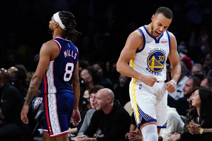 Golden State Warriors' Stephen Curry (30) celebrates as Brooklyn Nets' Patty Mills (8) walks away during the second half of an NBA basketball game Tuesday, Nov. 16, 2021 in New York. The Warriors won 117-99. (AP Photo/Frank Franklin II)