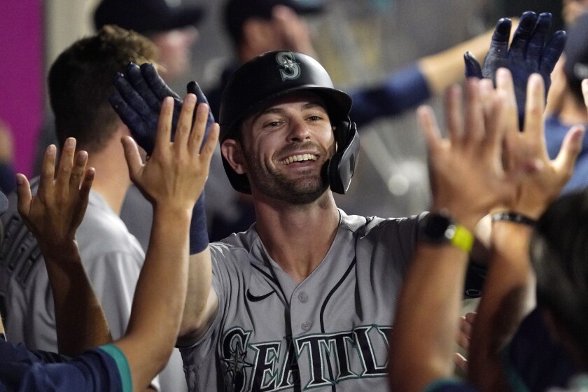 Seattle Mariners' Mitch Haniger is congratulated by teammates after hitting a two-run home run during the seventh inning of a baseball game against the Los Angeles Angels Friday, July 16, 2021, in Anaheim, Calif. (AP Photo/Mark J. Terrill)