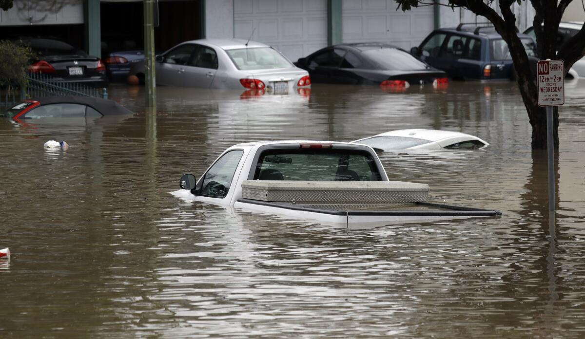 Floodwaters submerge cars in a San Jose neighborhood in February. (Marcio Jose Sanchez / Associated Press)