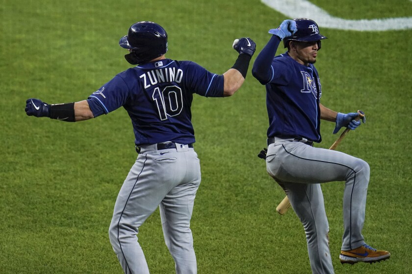 Tampa Bay Rays' Mike Zunino, left, celebrates near home plate with Willy Adames after hitting a two-run home run against Baltimore Orioles relief pitcher Tyler Wells during the third inning of a baseball game, Tuesday, May 18, 2021, in Baltimore. Rays' Joey Wendle scored on the home run. (AP Photo/Julio Cortez)