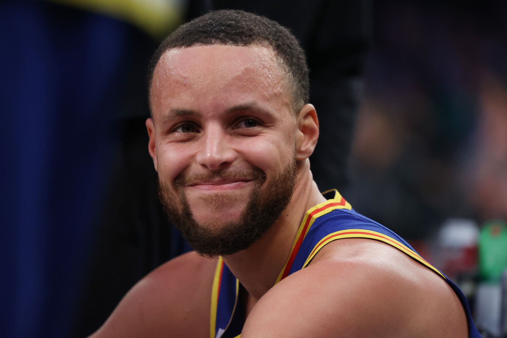 Stephen Curry smiles from the bench after making a three-point basket to break Ray Allen’s record.