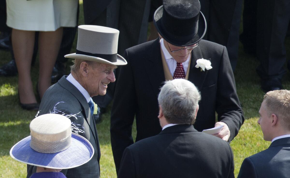 Prince Philip, left, the husband of Britain's Queen Elizabeth II, attends a garden party at Buckingham Palace. Buckingham Palace says Philip was later admitted to a London hospital for an exploratory operation.