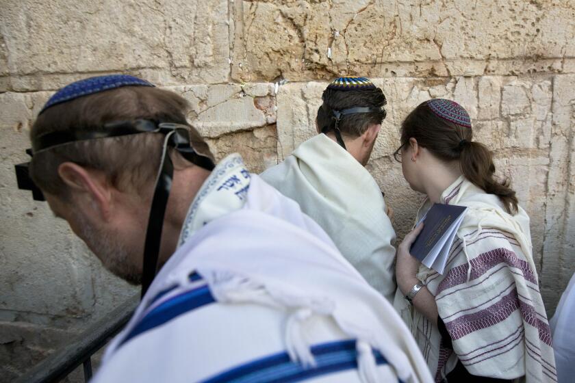 FILE - In this Feb. 25, 2016 file photo, American and Israeli Reform rabbis pray at the Western Wall, the holiest site where Jews can pray in Jerusalem's old city. Israel's Supreme Court on Monday, March 1, 2021, dealt a major blow to the country's powerful Orthodox establishment, ruling that people who convert to Judaism through the Reform and Conservative movements in Israel also are Jewish and entitled to become citizens. (AP Photo/Sebastian Scheiner, File)