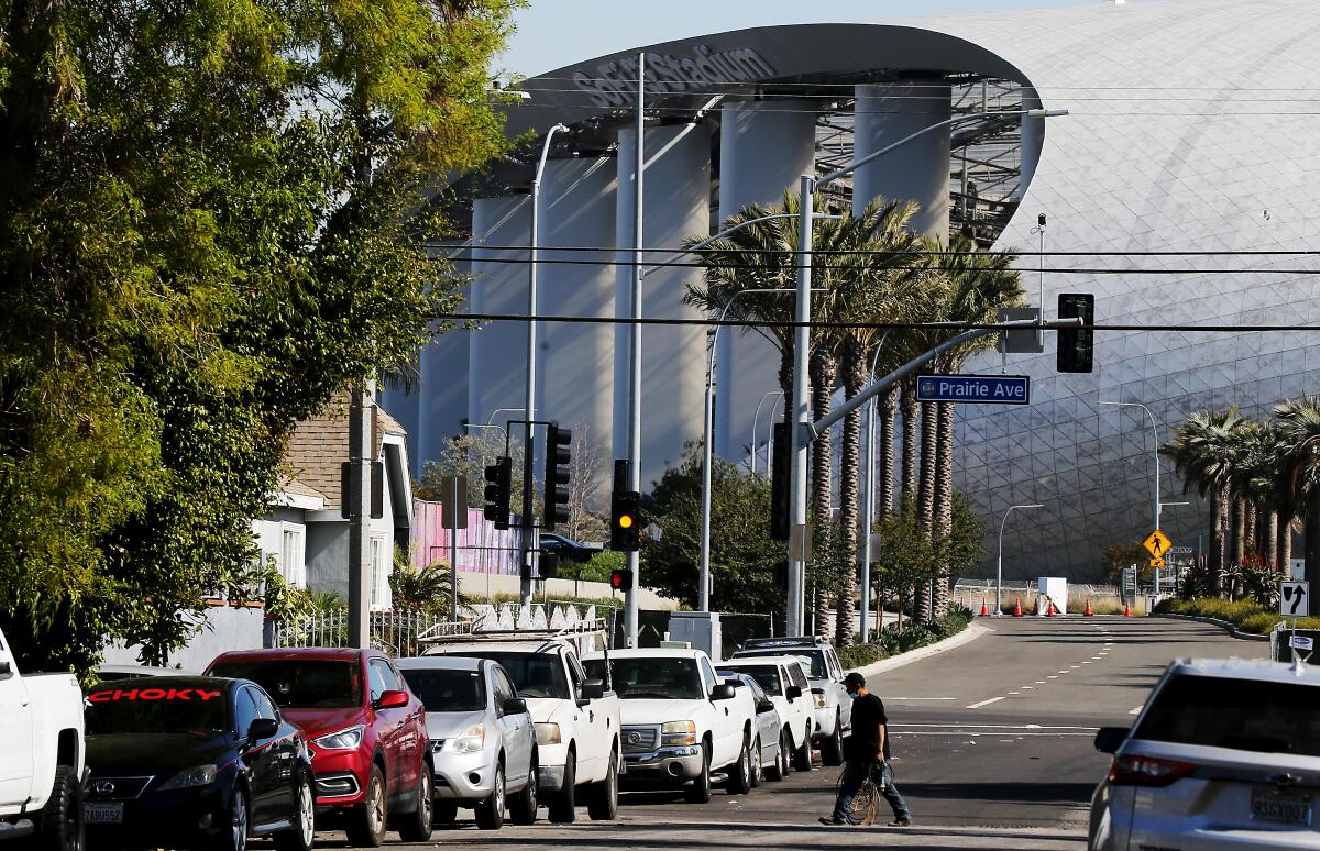 Cars with SoFi stadium in the background.