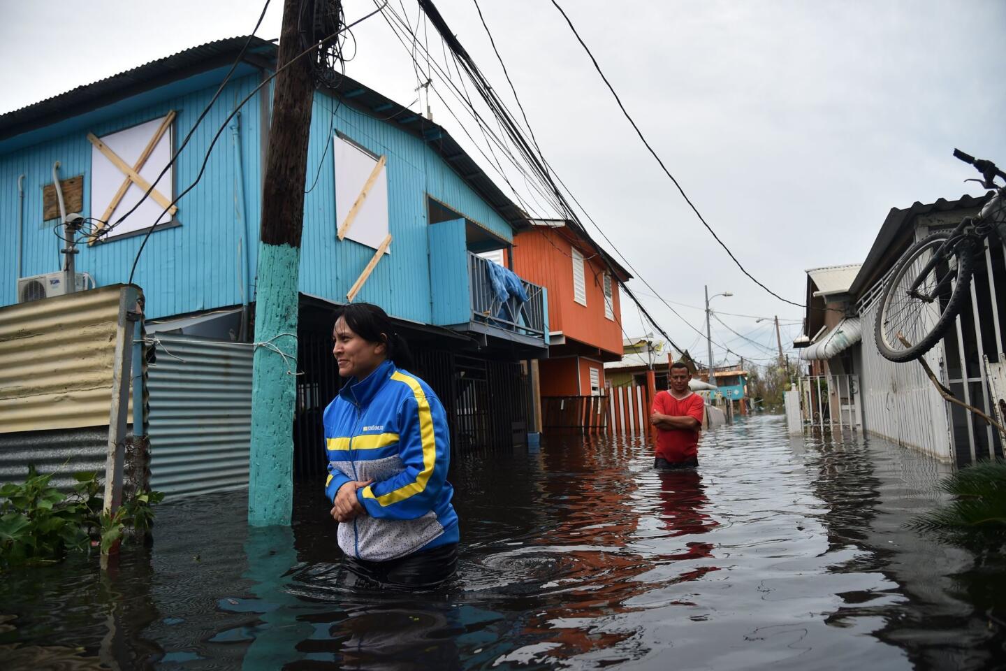 People walk across a flooded street in Juana Matos, Puerto Rico.