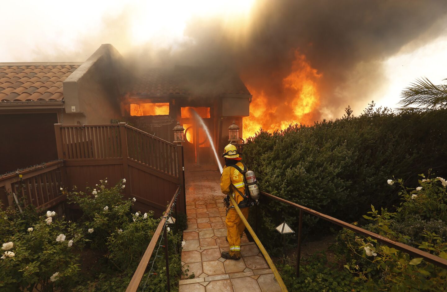 Chino Valley firefighters fight to save a home along Cobblestone Drive near Foothill Road in Ventura.