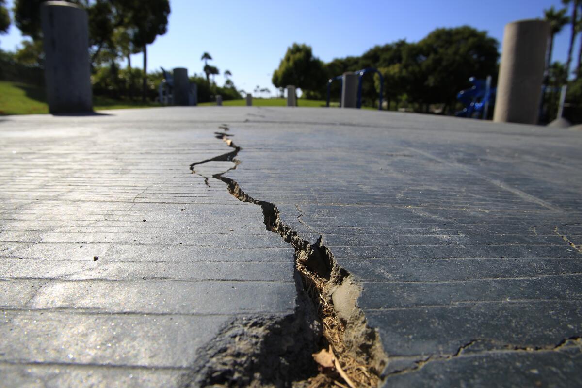 A long crack splits the sidewalk at the Discovery Well Park in the SeaCliff area of Huntington Beach