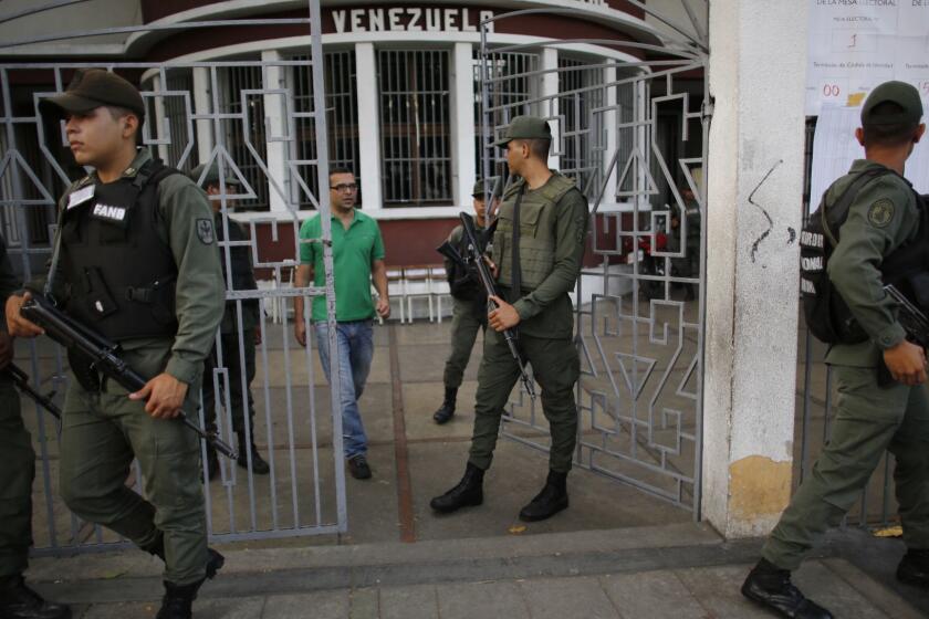 Bolivarian National Guards stand guard at a polling station during the presidential election in Caracas, Venezuela, Sunday, May 20, 2018. Amidst hyperinflation and shortages of food and medicine, President Nicolas Maduro is seeking a second, six-year term in an election that a growing chorus of foreign governments refuse to recognize after key opponents were barred from running. (AP Photo/Ariana Cubillos)