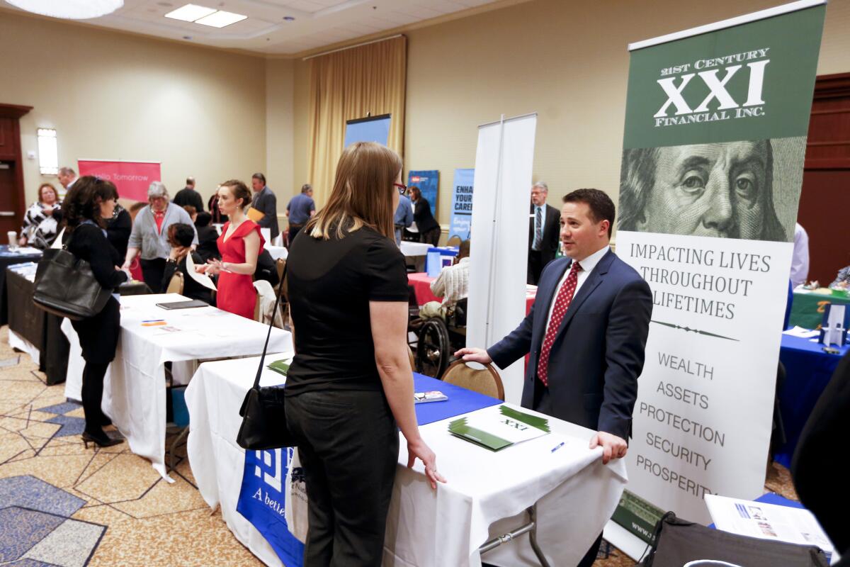 Companies speak with job seekers at a job fair in Pittsburgh on March 30.