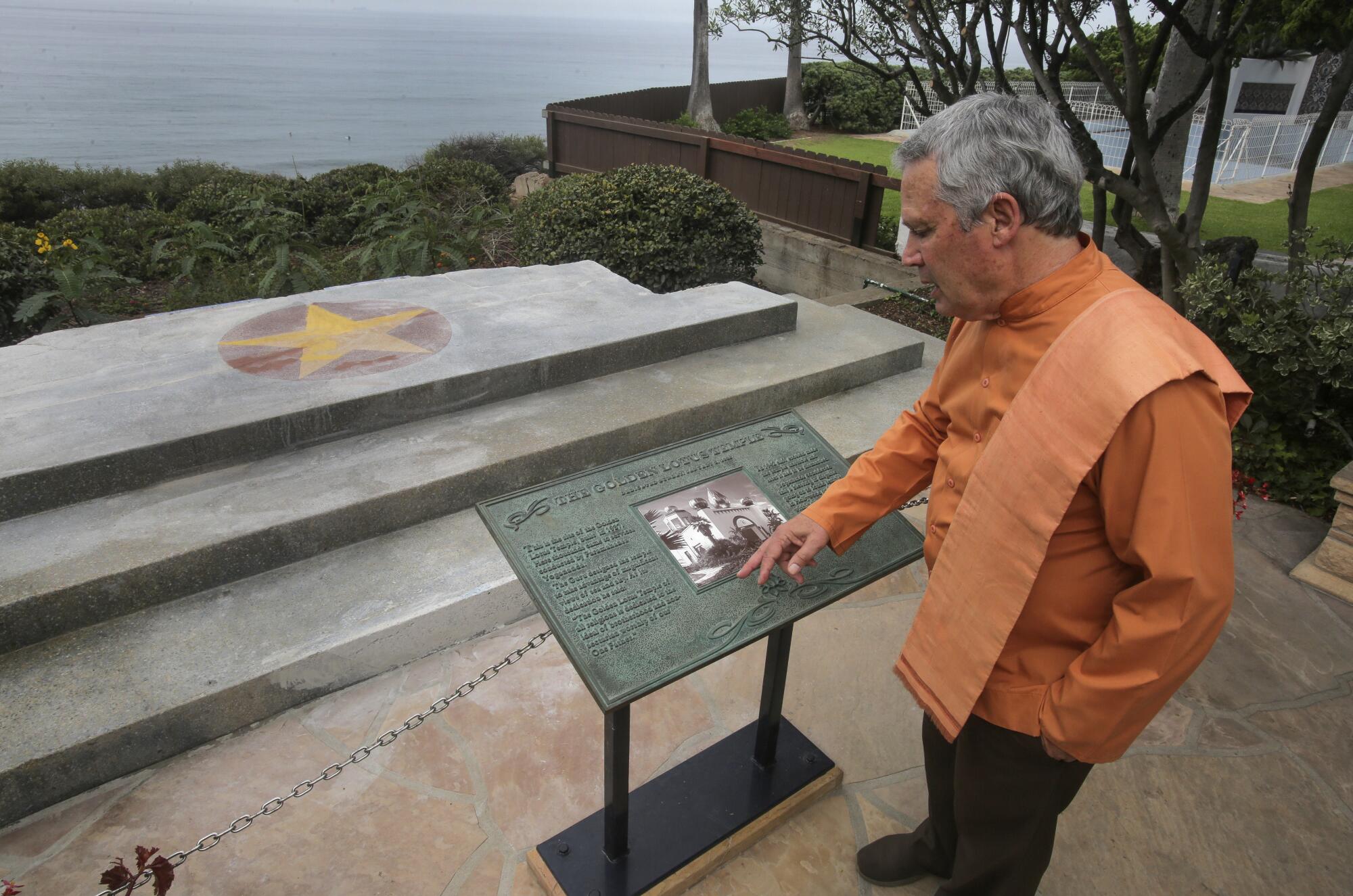 Brother Nakulananda shows the plaque that commemorates and features a photo of the Golden Lotus Temple.